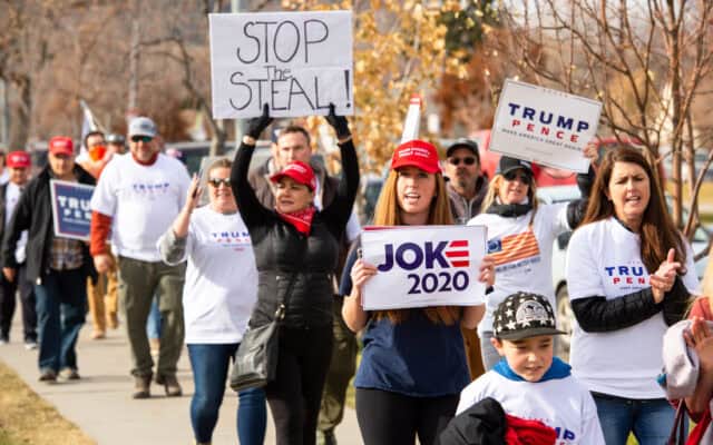Pro Trump supporters at Stop the Steal rally holding signs against the media declaring Joe Biden President elect due to voter fraud and vote count being incomplete